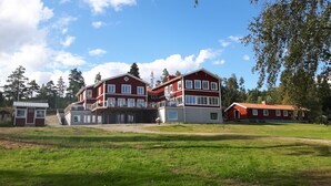 Un grand immeuble à plusieurs étages, à la façade rouge et aux ornements blancs, doté de nombreuses fenêtres et de balcons.