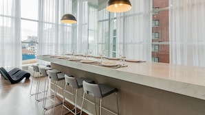 Una cocina moderna con una isla grande, taburetes de bar e iluminación colgante.