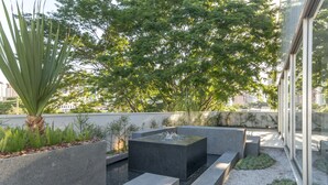 Een dakterras met een waterpartij, zitgedeeltes en diverse planten.