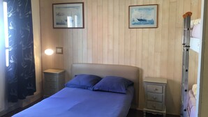 A bedroom with a bed, two nightstands, a dresser, and two framed pictures on the wall. - Auberge Riva Bella - Hostel (Le Touquet-Paris-Plage)