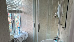 Un baño moderno con cabina de ducha de vidrio, un lavabo blanco y un inodoro.