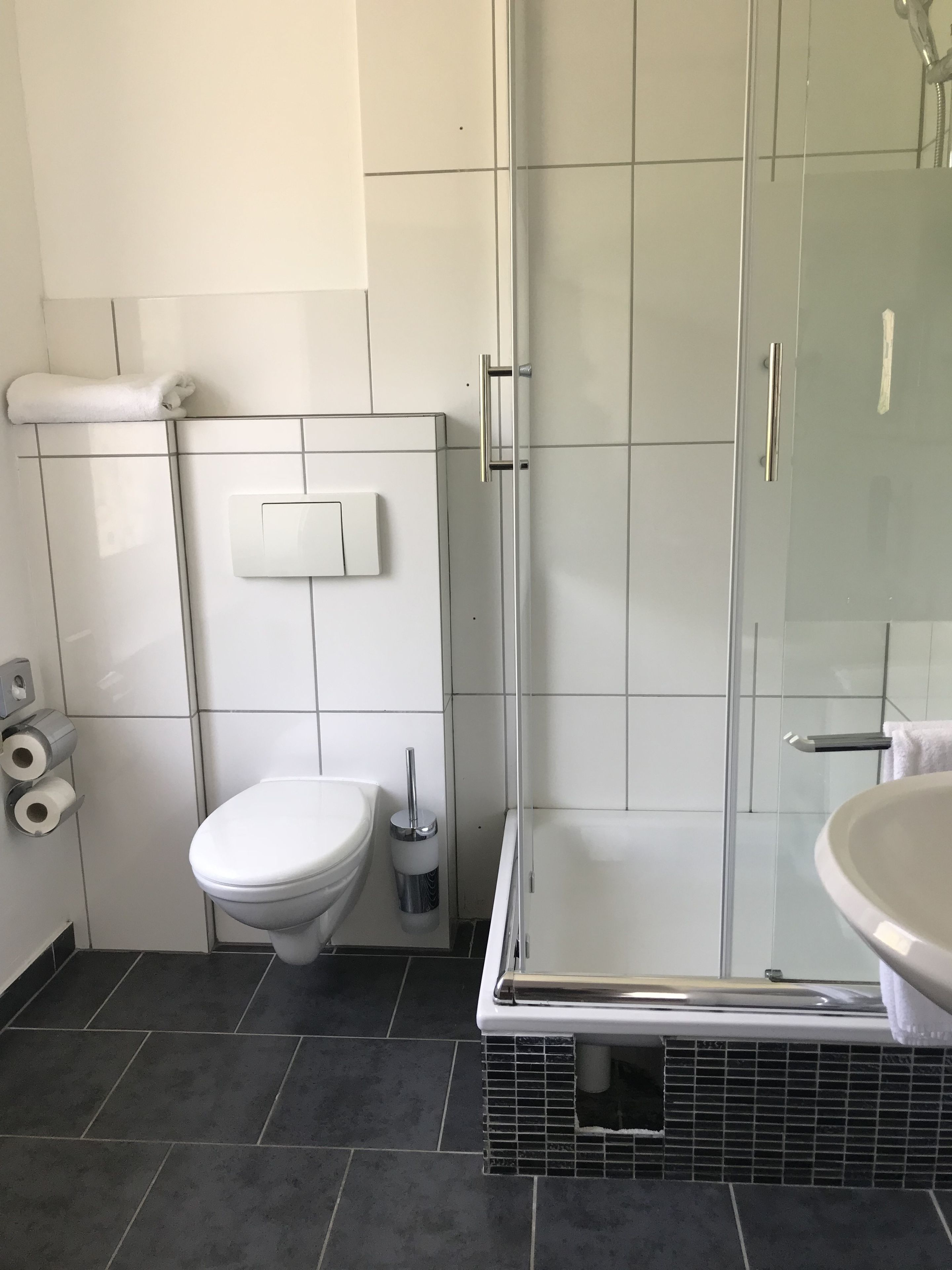 Ein modernes Badezimmer mit Toilette, Bidet und Duschkabine.