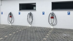 A row of electric vehicle charging stations with windows above them. - Aparthotel Nah dran (Loiching)