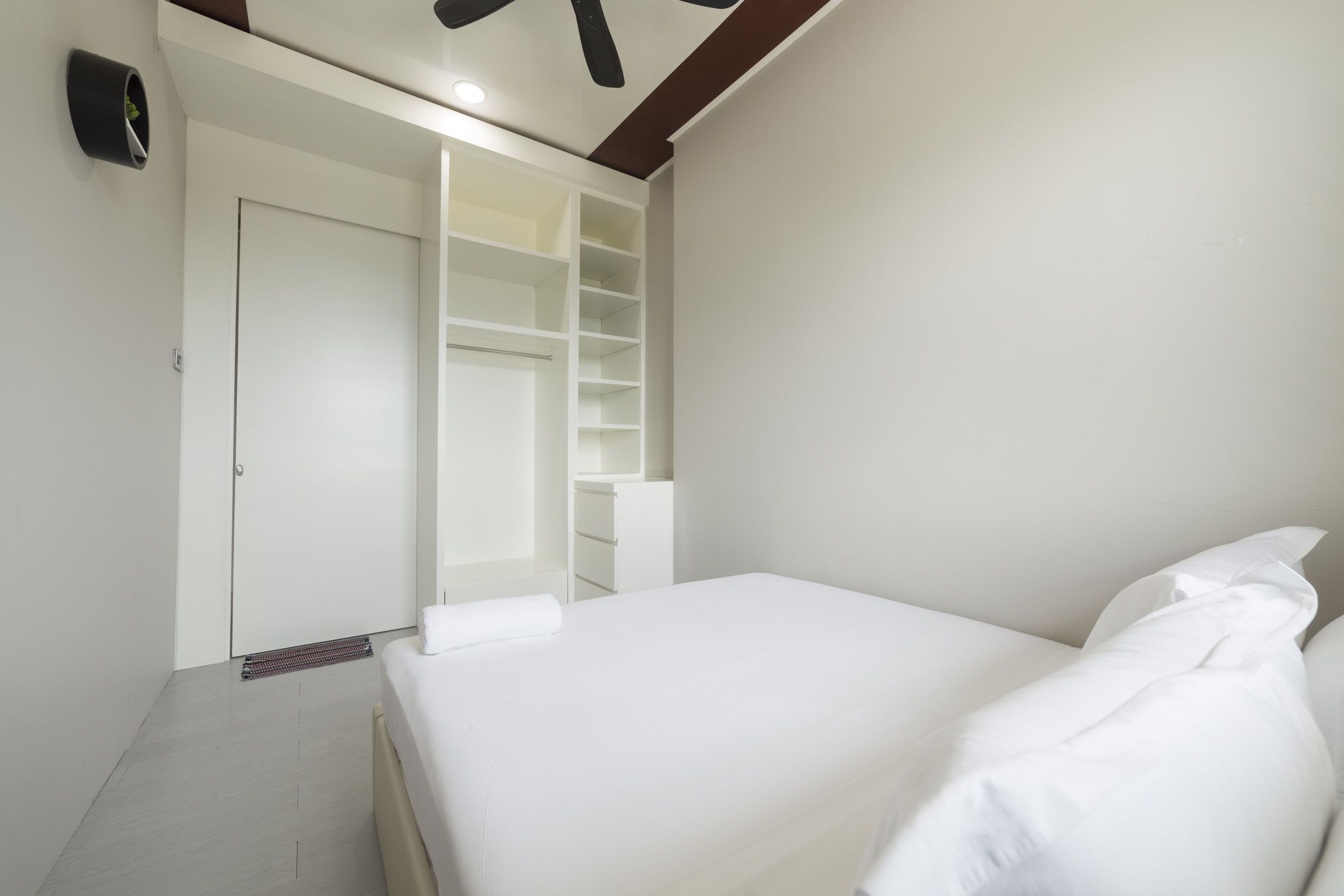 A bedroom with a bed, a walk-in closet, and a ceiling fan.