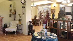 Un salon chaleureux avec une cheminée, un coin repas et une bibliothèque remplie de livres et d’objets décoratifs.