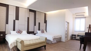 Une chambre d’hôtel moderne avec deux lits, un canapé, une petite table et une chaise.