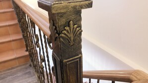 Un escalier en bois orné de balustres décoratives et muni d’une main courante.