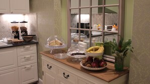Una cocina con gabinetes blancos, encimera de madera y ventana con vista a la cocina.