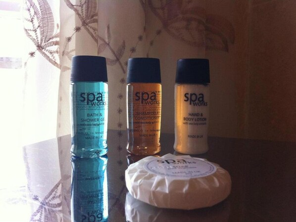 Three bottles of spa products on a reflective surface.