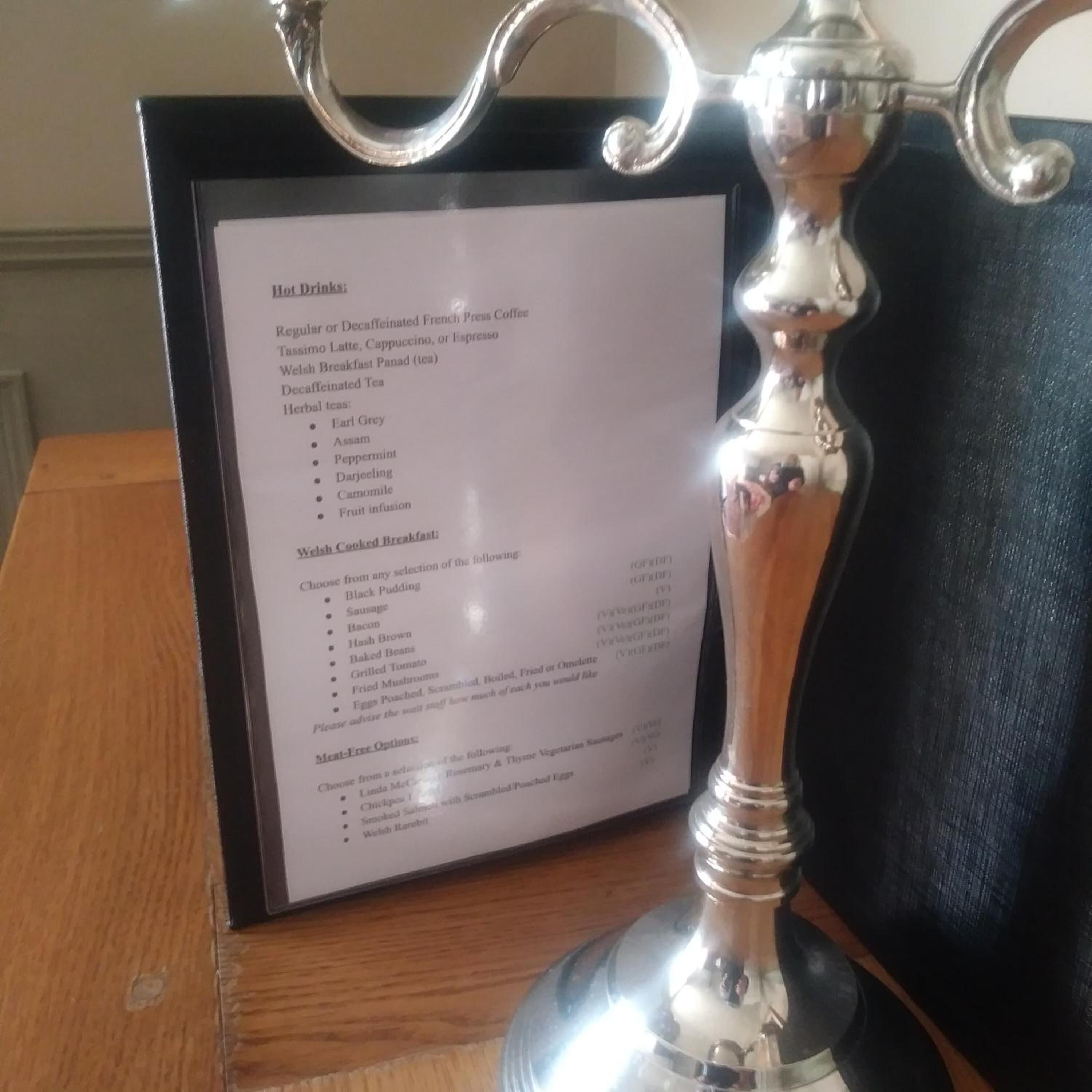 A menu board with a silver decorative holder.