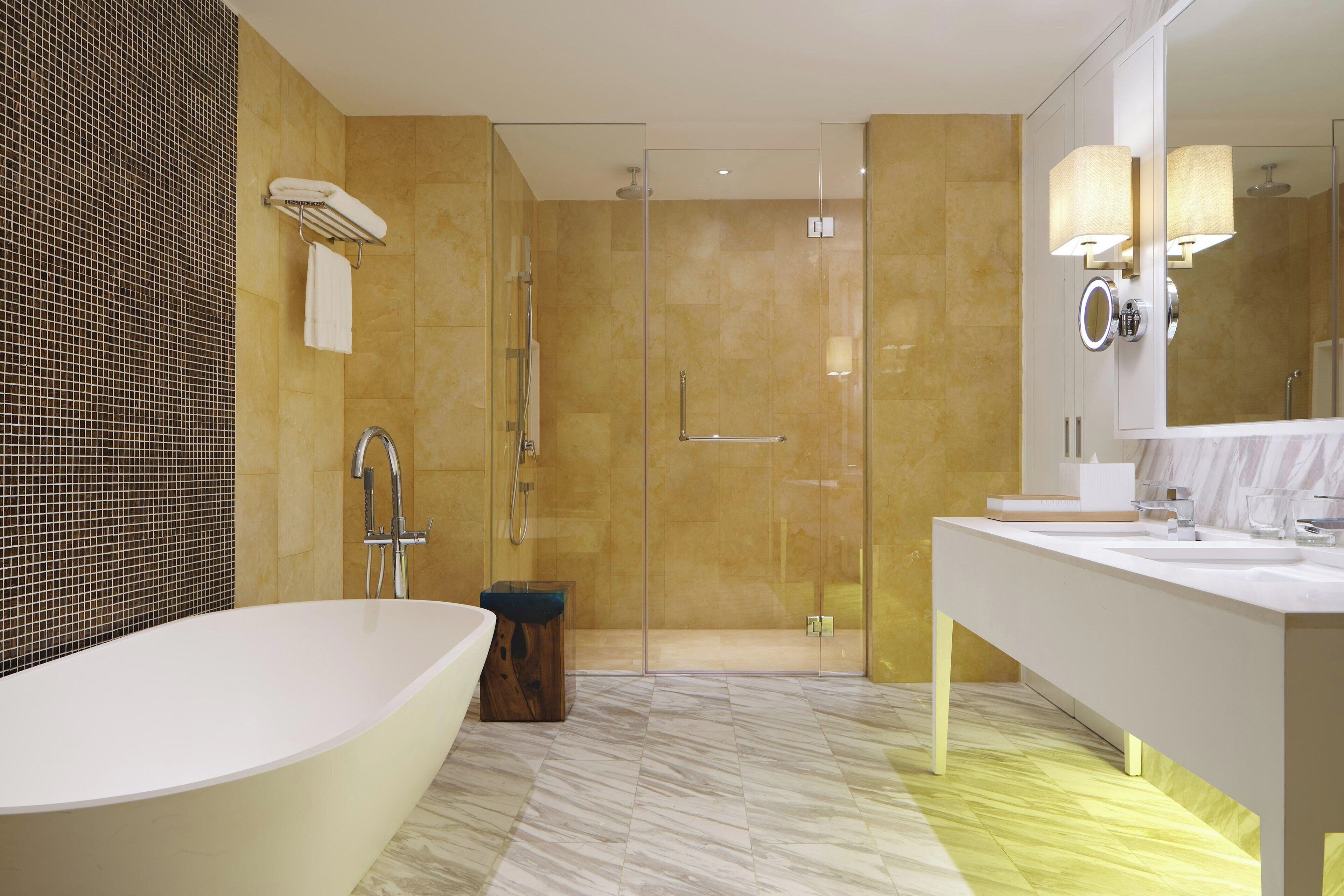 A modern bathroom with a freestanding bathtub, a glass-enclosed shower, and a vanity with a large mirror.