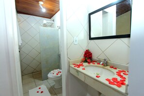 Een badkamer met toilet, wastafel en douche.