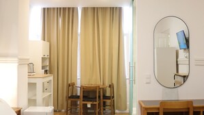 A hotel room with a bed, a desk, a chair, and a mirror. - MIDIS - Local Accommodation (Lisbon)