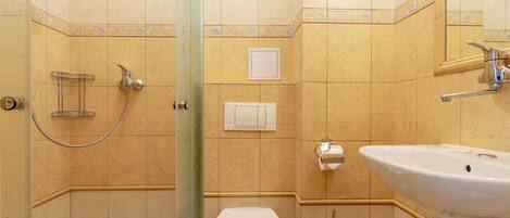 A bathroom with a bathtub, toilet, sink, and shower.