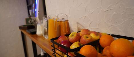 A fruit basket with apples and oranges on a wooden table.
