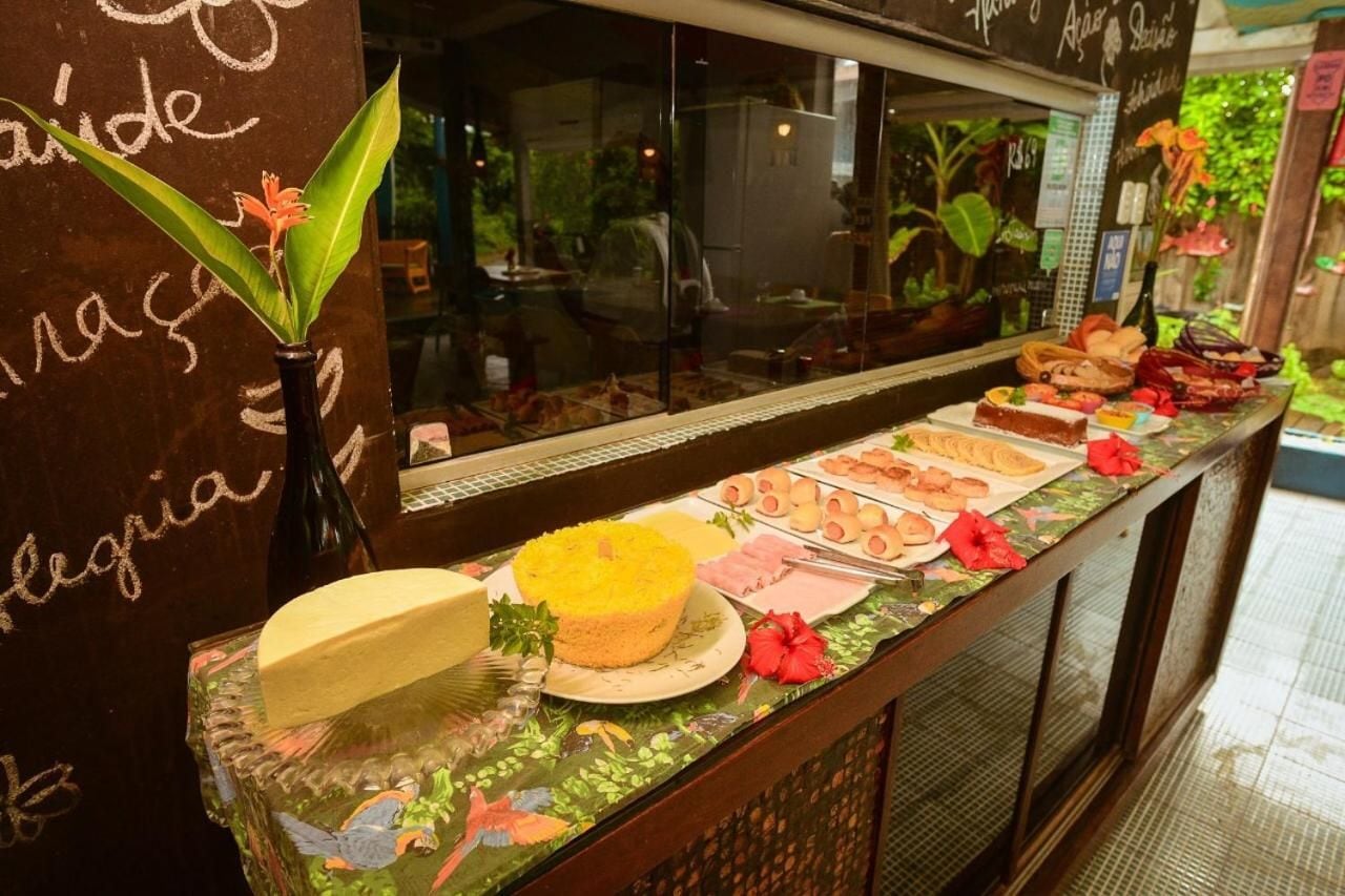 A buffet counter with various food items and a decorative plant.