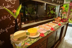 A buffet counter with various food items and a decorative plant.