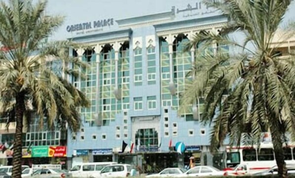 A building with a sign reading 'ORIENTAL POLICE' and palm trees in front.