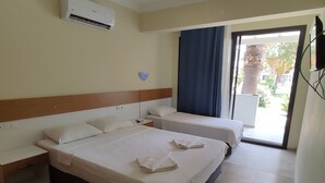 Ett hotellrum med två sängar, en takfläkt, en luftkonditioneringsanläggning och utsikt över omgivningarna.
