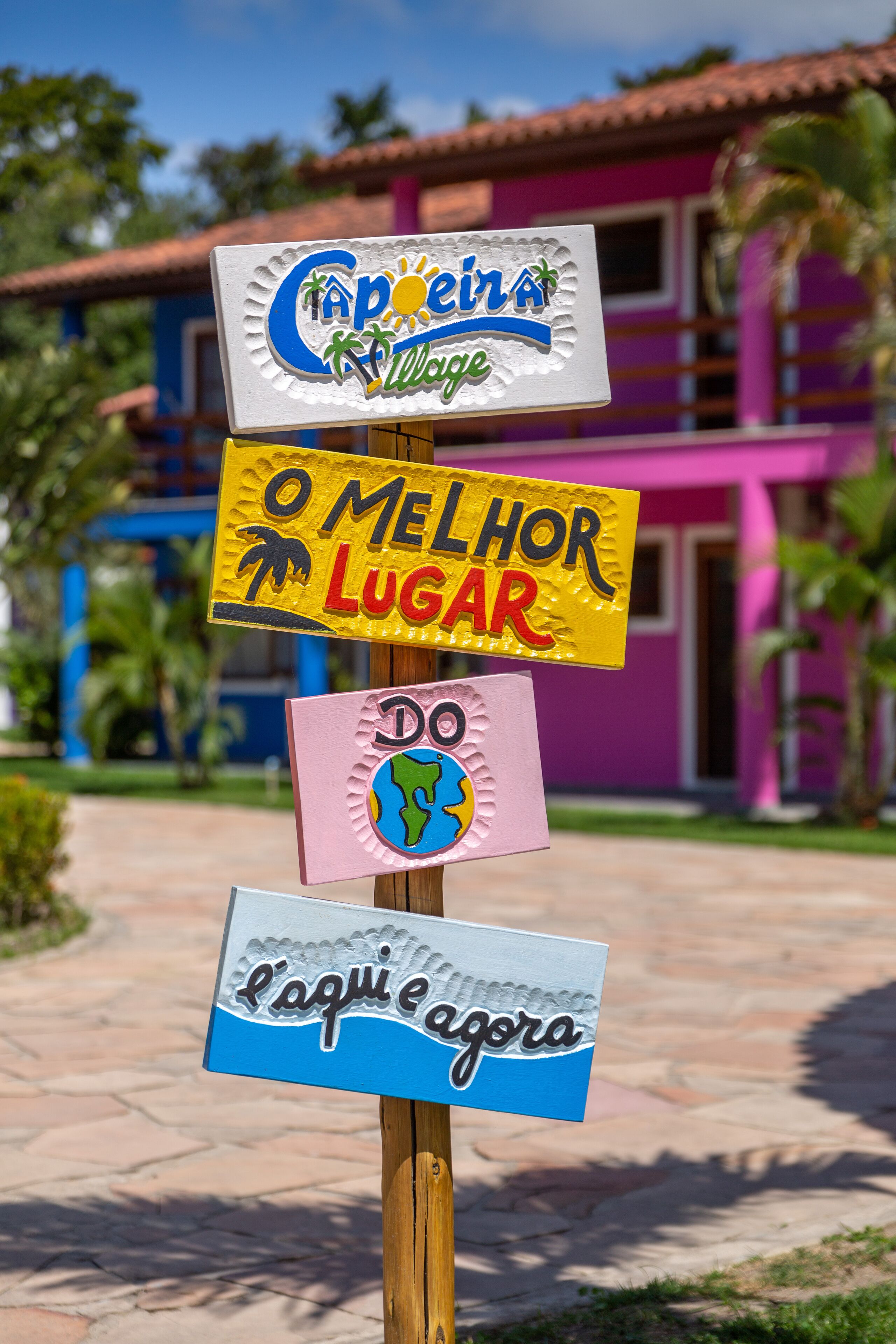 Un cartel con varios indicadores, incluyendo uno que dice "O Melhor Lugar" y otro que dice "Do Aqui e Agora".