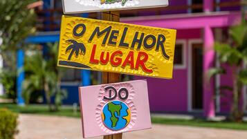 Un cartel con varios indicadores, incluyendo uno que dice "O Melhor Lugar" y otro que dice "Do Aqui e Agora".