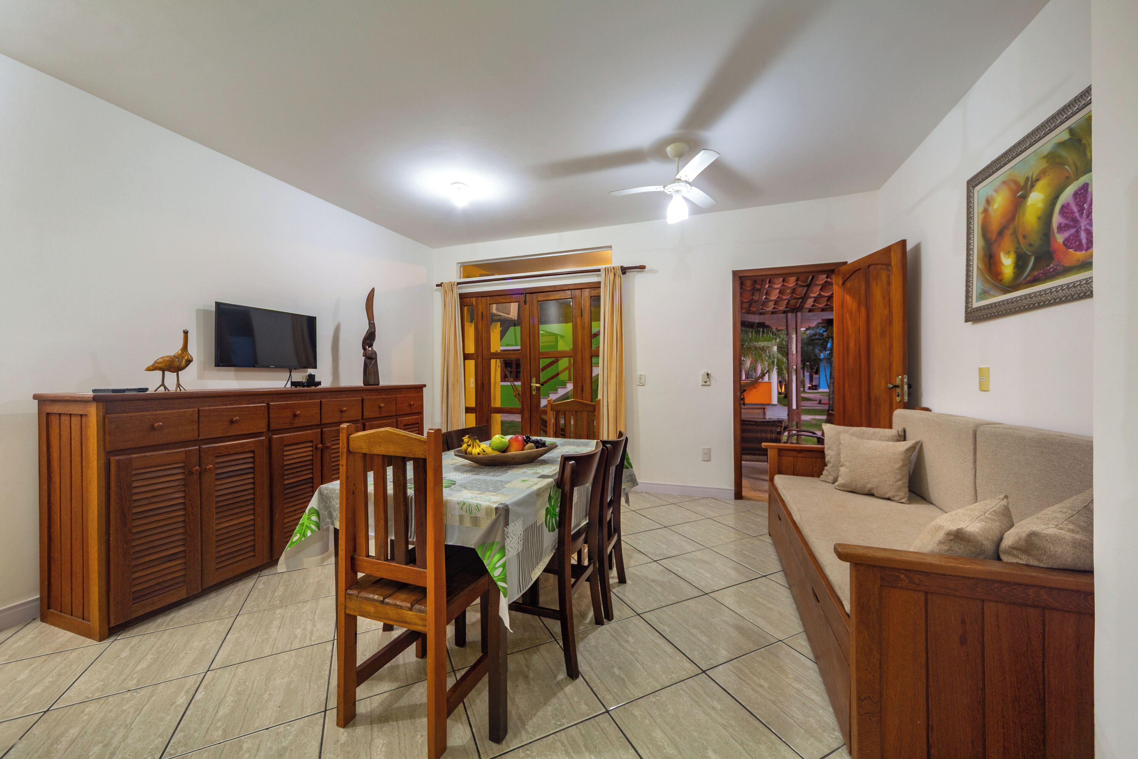 Un comedor con una mesa, sillas, un televisor y un sofá.
