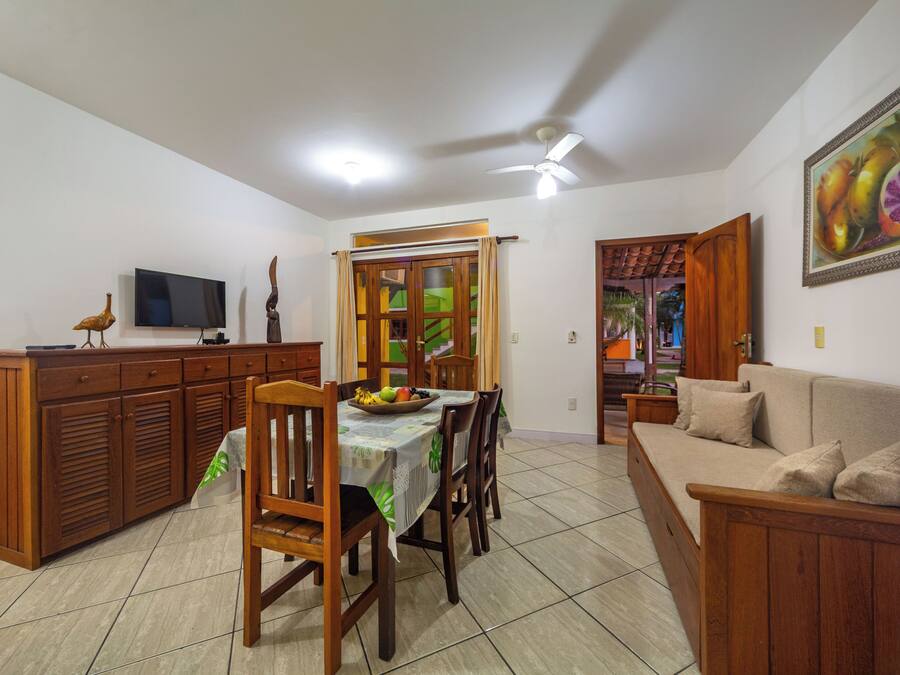 Un comedor con una mesa, sillas, un televisor y un sofá.