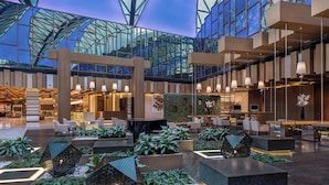 Un hall d’entrée spacieux, doté de meubles modernes, d’un atrium en verre et de plantes d’intérieur.