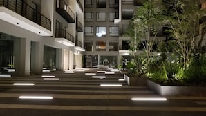 Um edifício moderno com vários andares, janelas amplas e uma escadaria central.