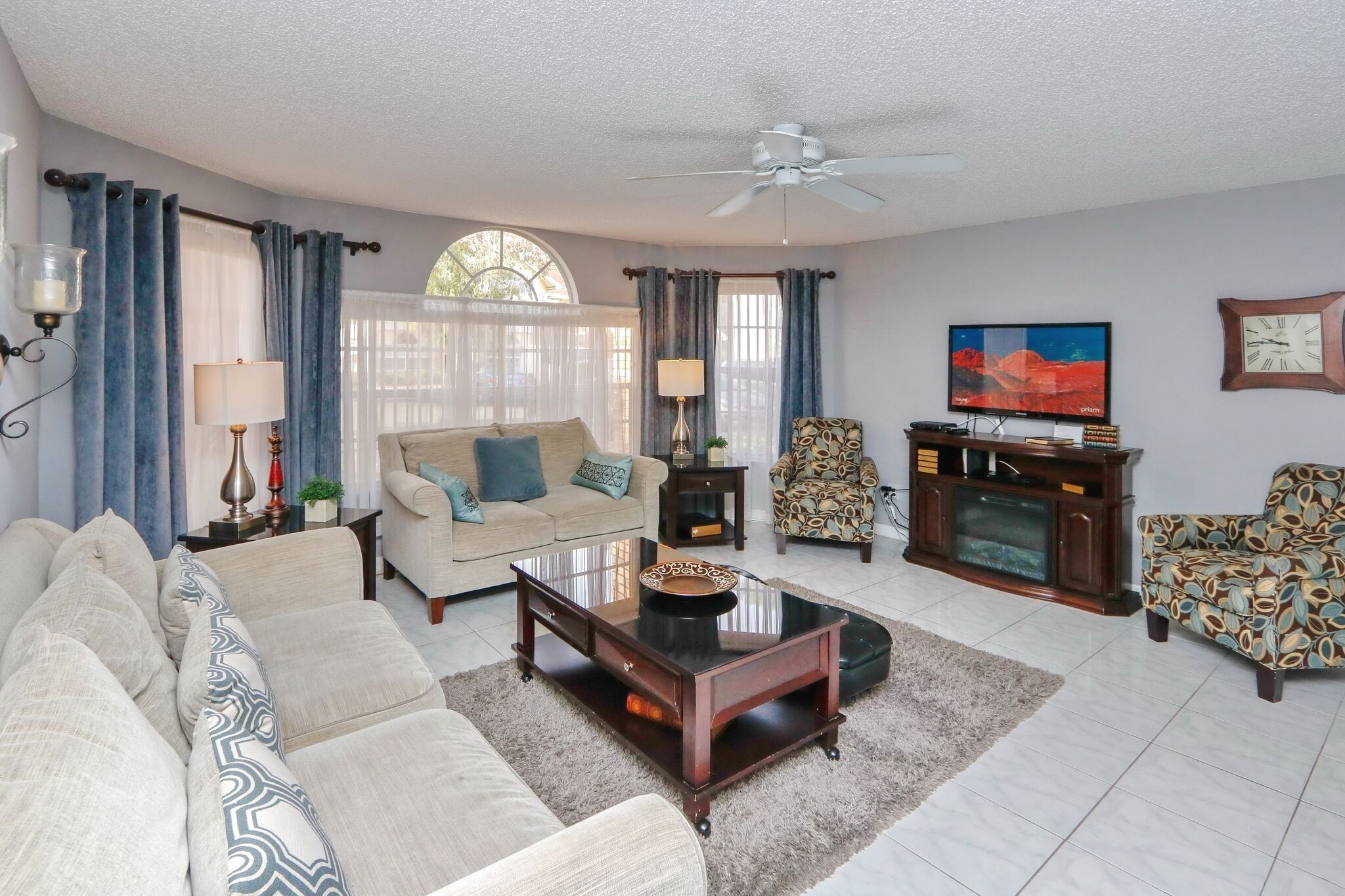 A living room with a sofa set, a coffee table, a TV, and a fireplace.