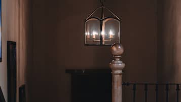 A staircase with a wooden balustrade and a hanging lantern with multiple candles.