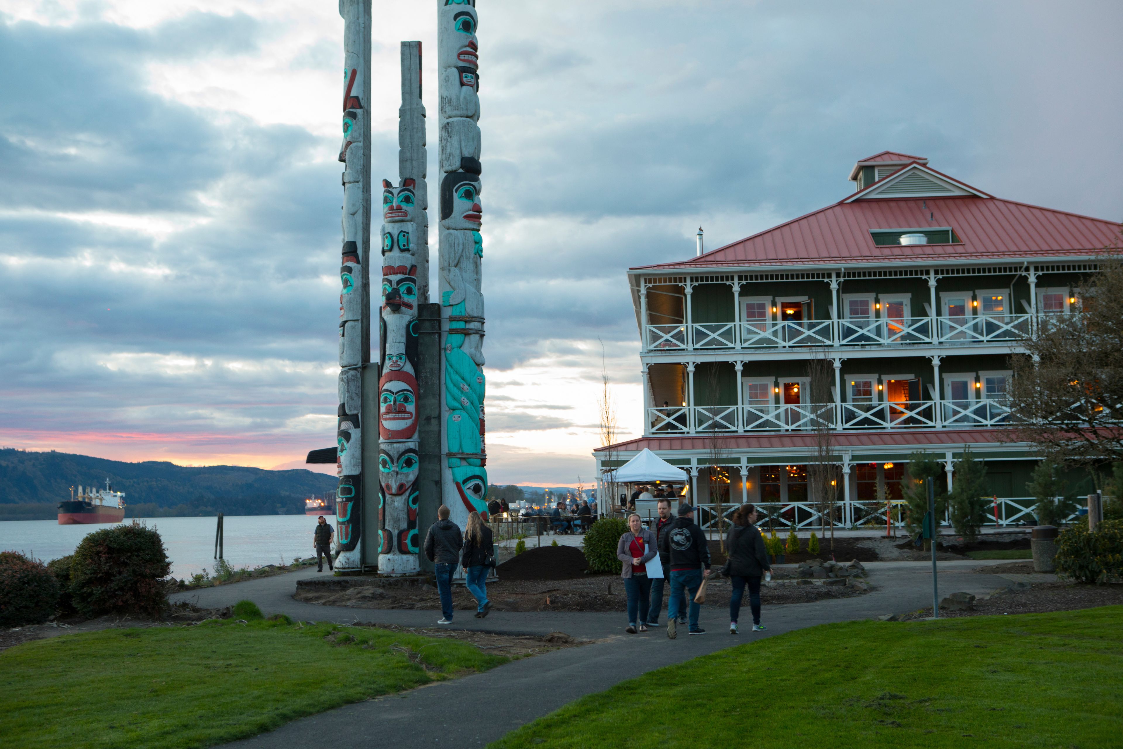 Un edificio sul lungomare con tetto rosso e facciata bianca, circondato da totem.