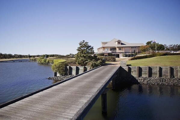 A waterfront property with a wooden dock leading to a house. - Harrington River Lodge (Harrington)
