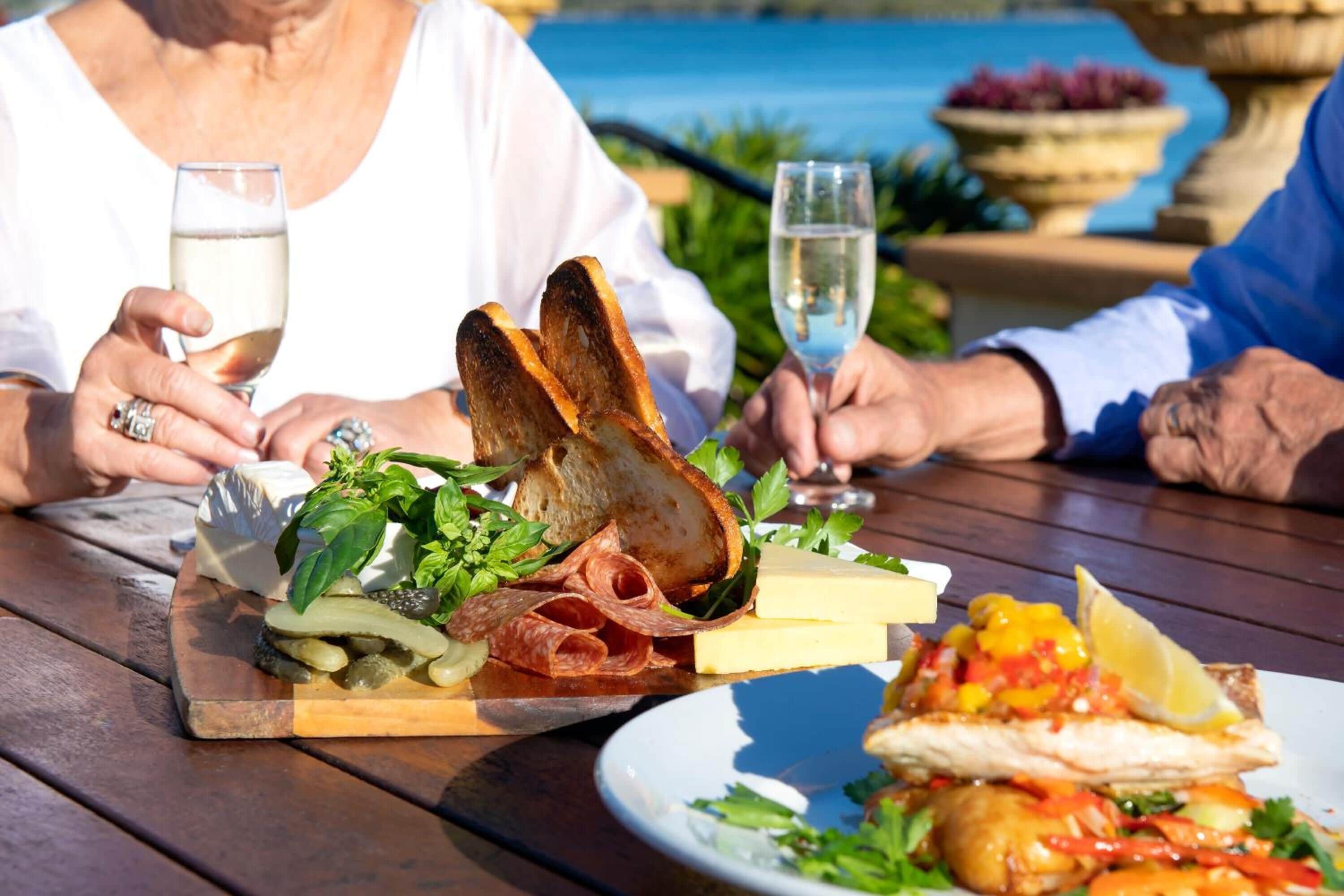 Uma mesa de jantar com diversos alimentos, incluindo pão, queijo e um prato com peixe.