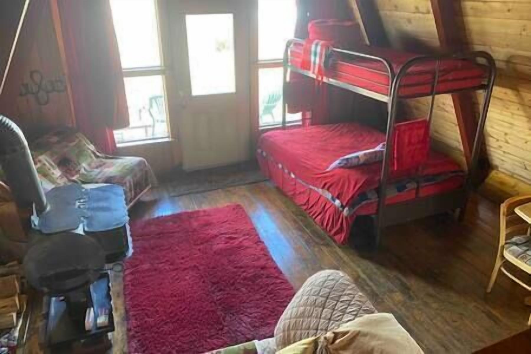 A room with a bunk bed, a desk, and a chair.