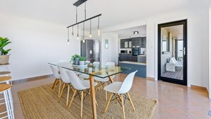A modern kitchen with dark cabinets, a stainless steel refrigerator, and a built-in oven.