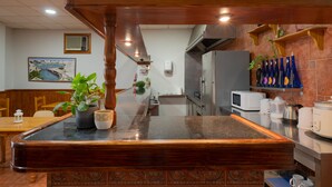 Un restaurante con mostrador de madera, un cuadro en la pared y un microondas en el mostrador.