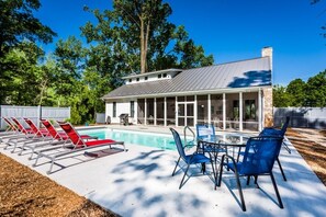 A modern house with a swimming pool, outdoor seating, and a covered patio area. - Gorgeous Modern Cottage With Private Pool And Close To Beach! (Union Pier)