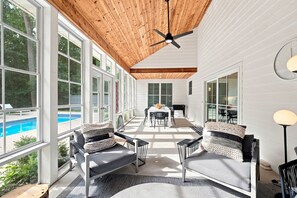A spacious indoor area with a pool view, wooden ceiling, and modern furniture. - 2027 Calendar OPEN! Modern Cottage With Private Pool And Close To Beach! (Union Pier)