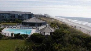 A beachfront hotel with a swimming pool, beach access, and a view of the ocean.