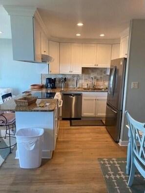 Enjoy cooking in this well-equipped kitchen with a granite countertop, dishwasher, and coffee maker.