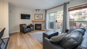 Un salon moderne avec une cheminée, un canapé en cuir et un coin repas.