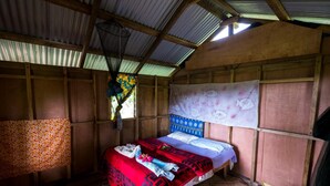 A room with a bed, a hammock, and a wall with a fish pattern. - Castle Tree House (Tanna Island)
