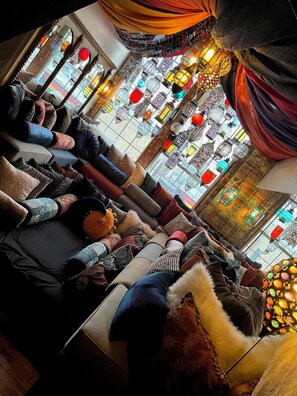 A cozy lounge area with plush seating and decorative lanterns.