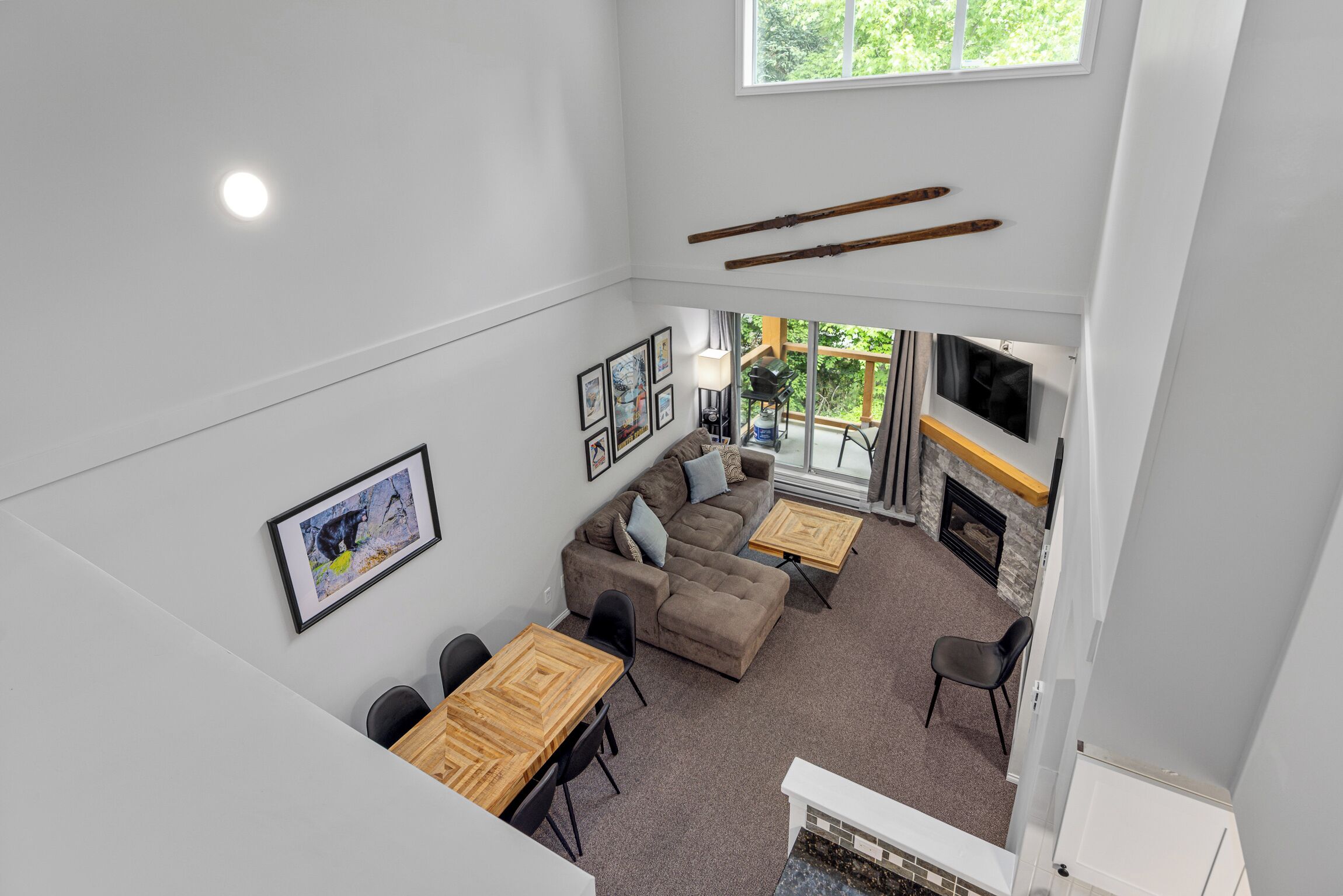 A spacious living area with a sofa set, a dining table, and a fireplace.
