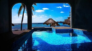 A pool with clear blue water, a view of the ocean, and palm trees. - Amazing View Oceanfront with 2 pools, Daily Housekeeping (Akumal)