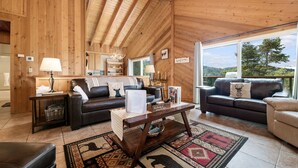 A cozy wooden interior with two sofas, a coffee table, and a rug. - Wolf View Lodge - Air Conditioning, Close to Slopes, Views, Fireplace, Deck, BBQ (Big Bear City)