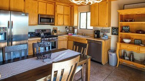 A wooden kitchen with a refrigerator, stove, microwave, and sink. - Wolf View Lodge - Air Conditioning, Close to Slopes, Views, Fireplace, Deck, BBQ (Big Bear City)