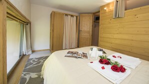 A neatly made bed with a magazine, rolled towels, and a bouquet of red roses. - Grand Roc A104 150m from Slopes, Parking & WiFi, Argentière (Chamonix), France (Argentière (Chamonix))