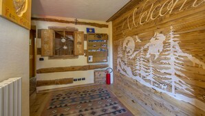 A wooden interior with a 'Welcome' sign, a wooden cabinet, and a patterned rug. - Perla Ski in, Livigno, Italy (Livigno)